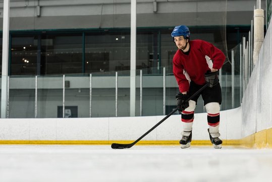Full length of player playing ice hockey at rink
