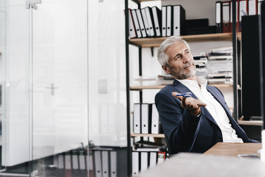 Mature businessman in office with fidget spinner