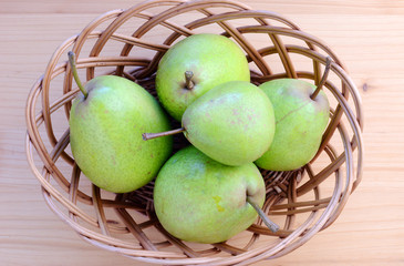 Ripe organic pears on a wooden table, top view.
