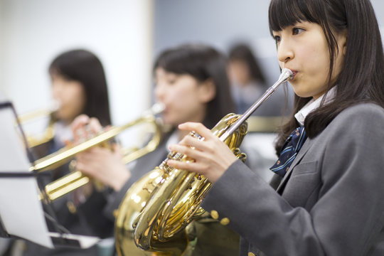 Students practicing brass instruments in music room