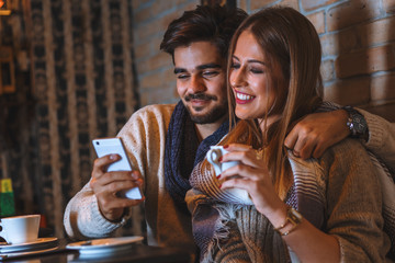 Beautiful young couple drinking coffee in cafe.