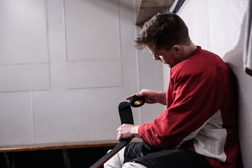 Male player taping ice hockey stick
