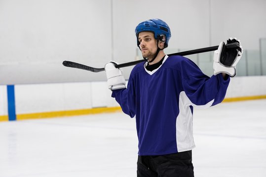 Player holding ice hockey stick at rink