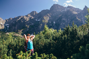 Young sports girl walking in a picturesque place in the middle of the mountains near the lake