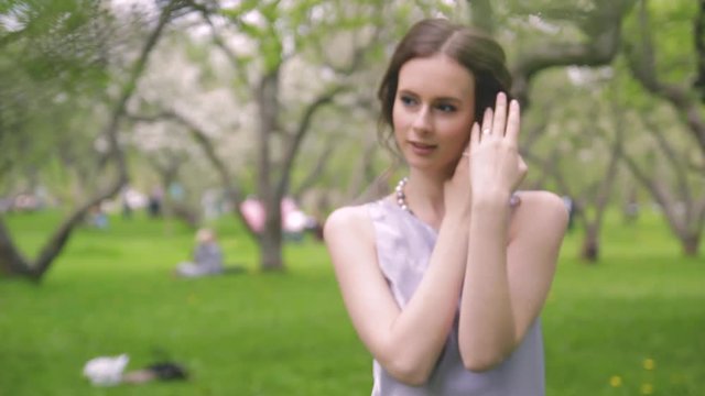 beautiful brunette in a lilac dress is walking in the park, a simatic girl of Caucasian appearance