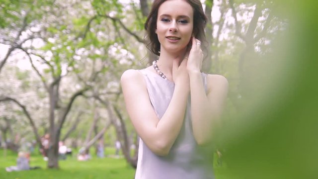 beautiful brunette in a lilac dress is walking in the park, a simatic girl of Caucasian appearance