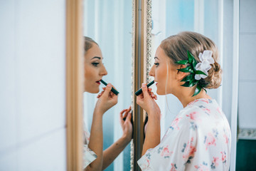 The bride is preparing for the wedding day in the morning, bride's in front of the mirror. 