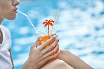 Model drinking orange cocktail