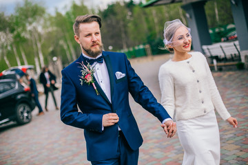 Happy newlywed couple on a walk in old European town street, gorgeous bride in white wedding dress...