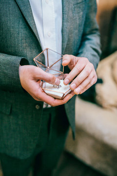 picture of man with glass decorated gift box and wedding ring