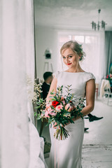 Beauty portrait of bride wearing fashion wedding dress with feathers with luxury delight make-up and hairstyle, studio indoor photo. Young attractive Caucasian model. 