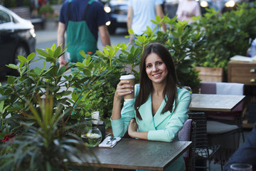 Young beautiful brunette woman sitting in a restaurant