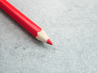 Red color pencil on bare cement or concrete wall background 1