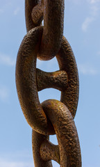 Detail of an old rusty chain on a blue background