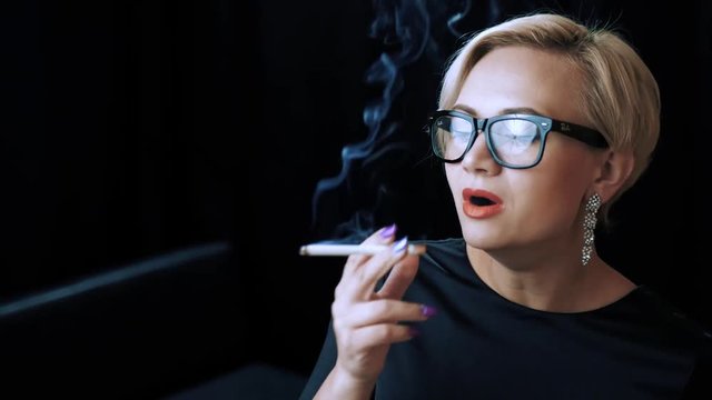 Seductive  assistant is enjoying a long-awaited 120mm after a tough day at the office. After making a long inhale the blonde-haired girl can easily forget about the stressful events of the day..