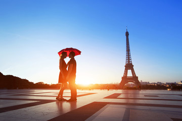 Fototapeta na wymiar romantic couple in Paris, man and woman under umbrella near Eiffel Tower, honeymoon