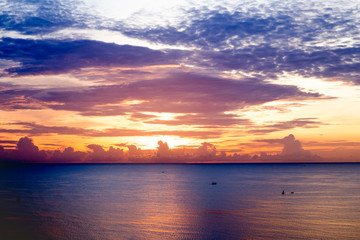 Naklejka na ściany i meble sunrise over ocean with fishing boat and colorful sky