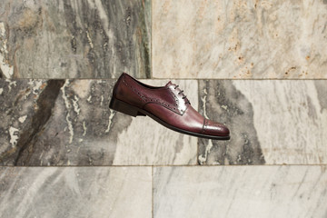 Men's brown classic oxford shoes on a marble background. Fashion advertising shoes photos.