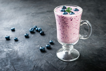 Fototapeta na wymiar blueberry smoothie with fresh berries on a dark background