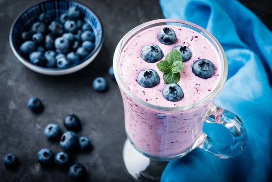 Smoothie or milkshake with  blueberries  in a  jar on dark  table