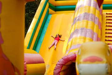 cheerful naughty girl on an inflatable hill