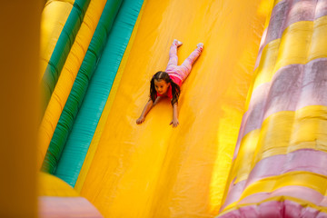 cheerful naughty girl on an inflatable hill