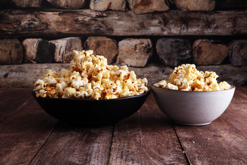 Salt popcorn or sweet popcorn in bowl on the wooden table