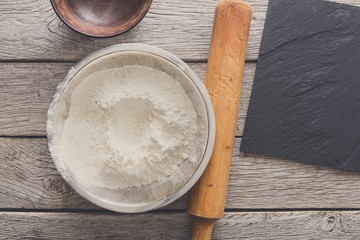 Baking concept. Flour and rolling pin on wood