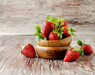 Fresh strawberries in a wooden bowl, selective focus
