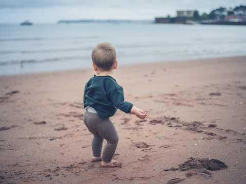 Little baby standing on the beach