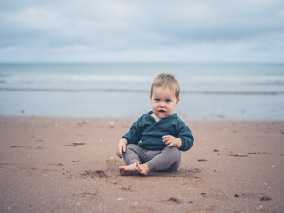 Fototapeta na wymiar Little baby sitting on the beach