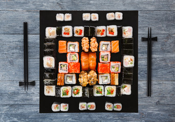 Set of sushi, maki and rolls on blue wood background