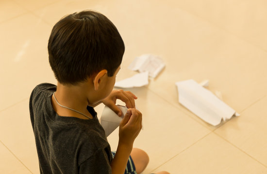 Little boy making paper plane