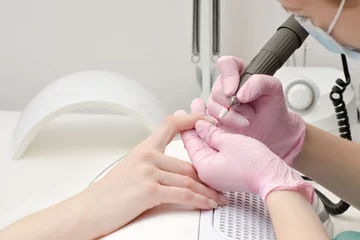 Zelfklevend Fotobehang Girl in gloves handles nails with a milling cutter for manicure © somemeans