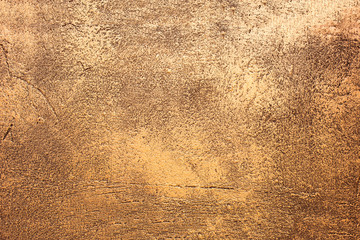 Close up texture of golden decorative plaster wall with natural light. Golden shiny background. Golden shiny plaster. Gold texture. Gold.