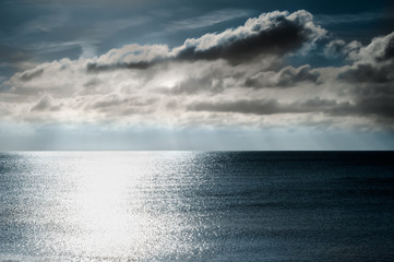 Shimmering Light on Sea with Moody Dark Sky