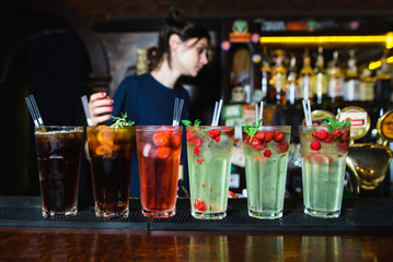 beautiful alcoholic cocktails are at the bar of the nightclub.