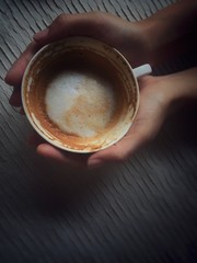 A cup of cappuccino in hand