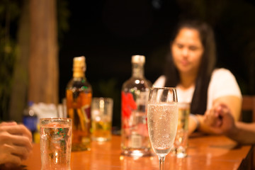 Glass of champagne with people holding glasses making a toast for celebration