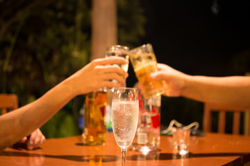 Glass of champagne with people holding glasses making a toast for celebration