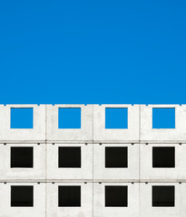 Fragment of a building under construction against a blue sky, abstract background.