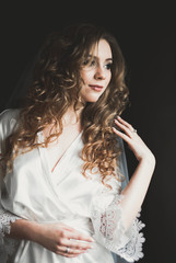 Naklejka premium Luxury bride in white dress posing while preparing for the wedding ceremony