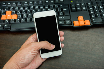 hand using mobile phone at computer