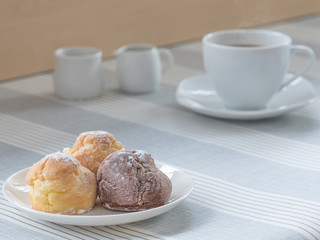 a dish of chou cream with a cup of tea or coffee for an afternoon break.