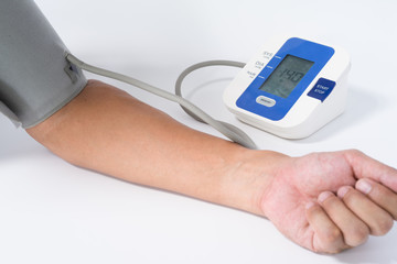 Digital Blood Pressure Monitor with the arm of a man on white background