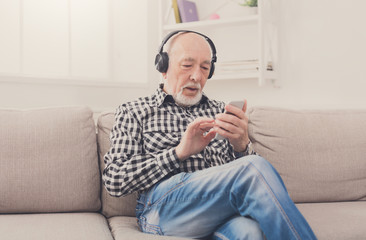 Senior man listening to music with headphones