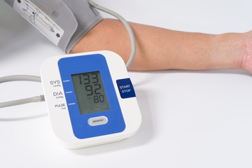Digital Blood Pressure Monitor with the arm of a man on white background