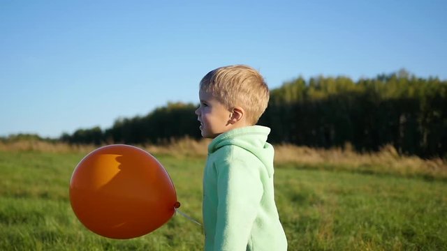 Happy boy plays with balloon in the Park. Walking and outdoor activities