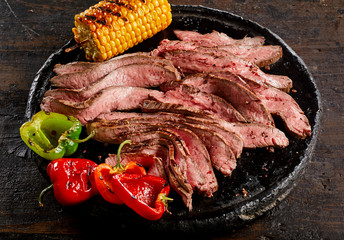 Grilled flank steak thinly sliced on a plate