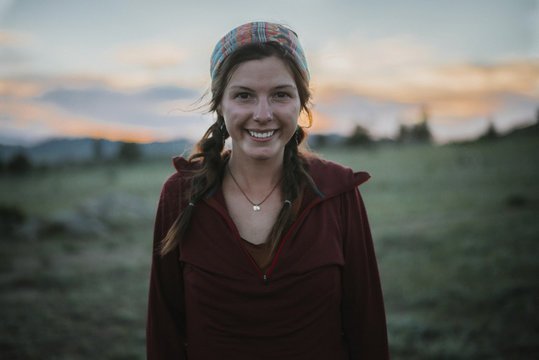 Portrait Of Happy Woman Standing At Field During Sunset